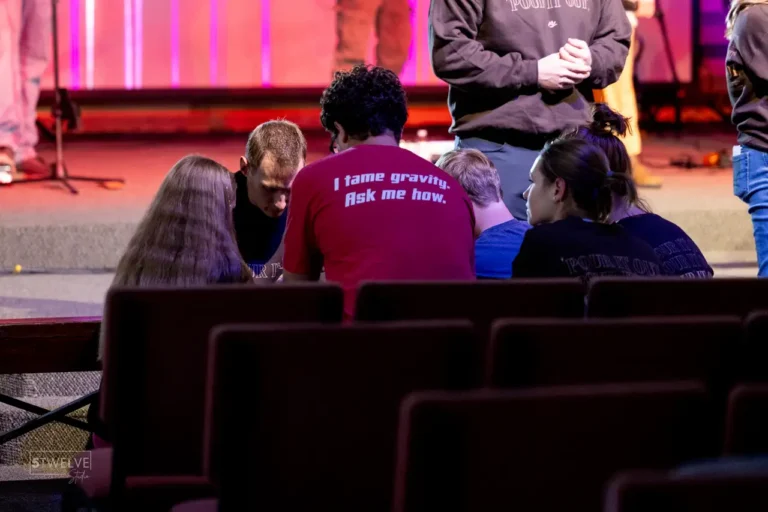 Students praying together at a youth group retreat