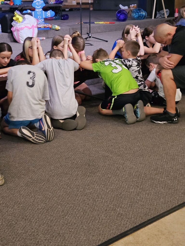 Campers gathered in pray at a Christian retreat center